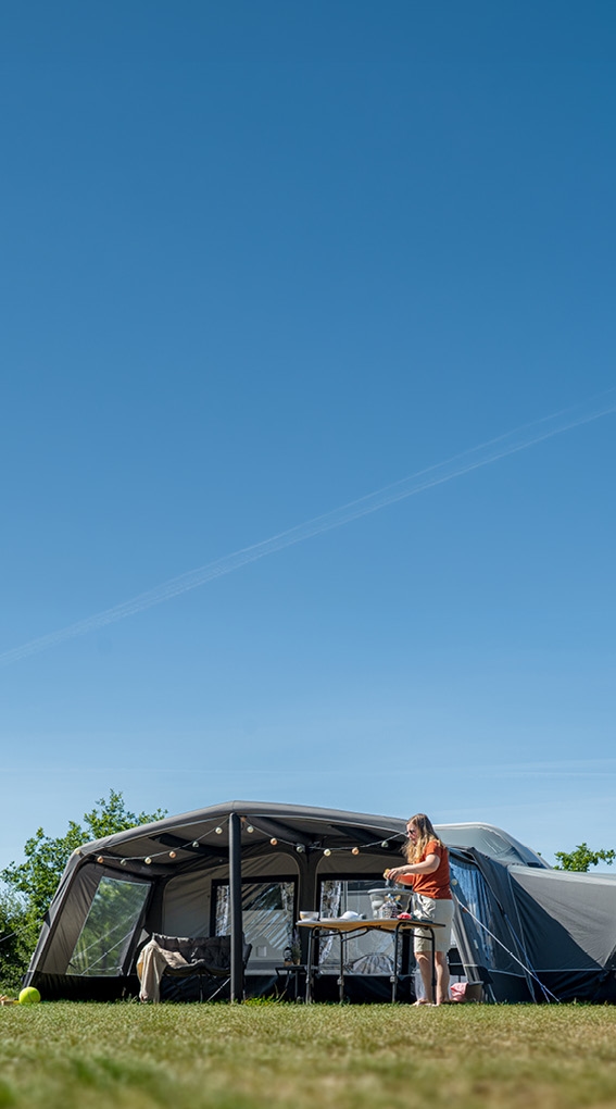 Camper voortent met buitenkeuken onder zonnige lucht
