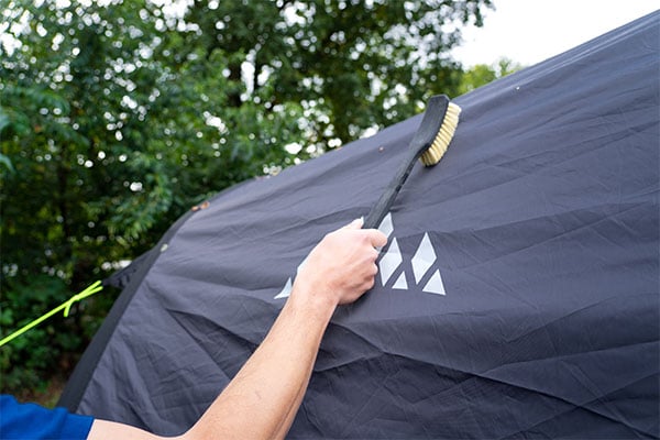 tentborstel op tentdoek om schoon te maken